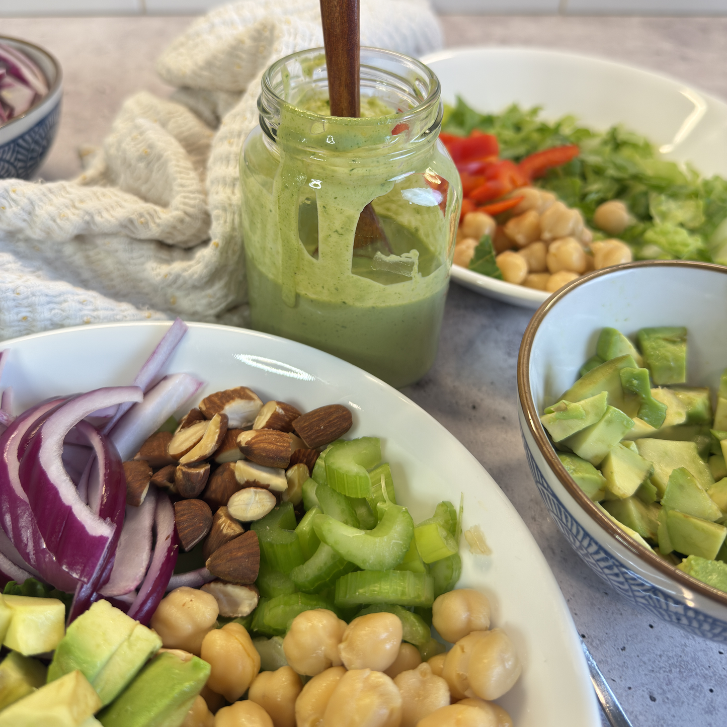 image of tahini dressing surrounded by bowls of food