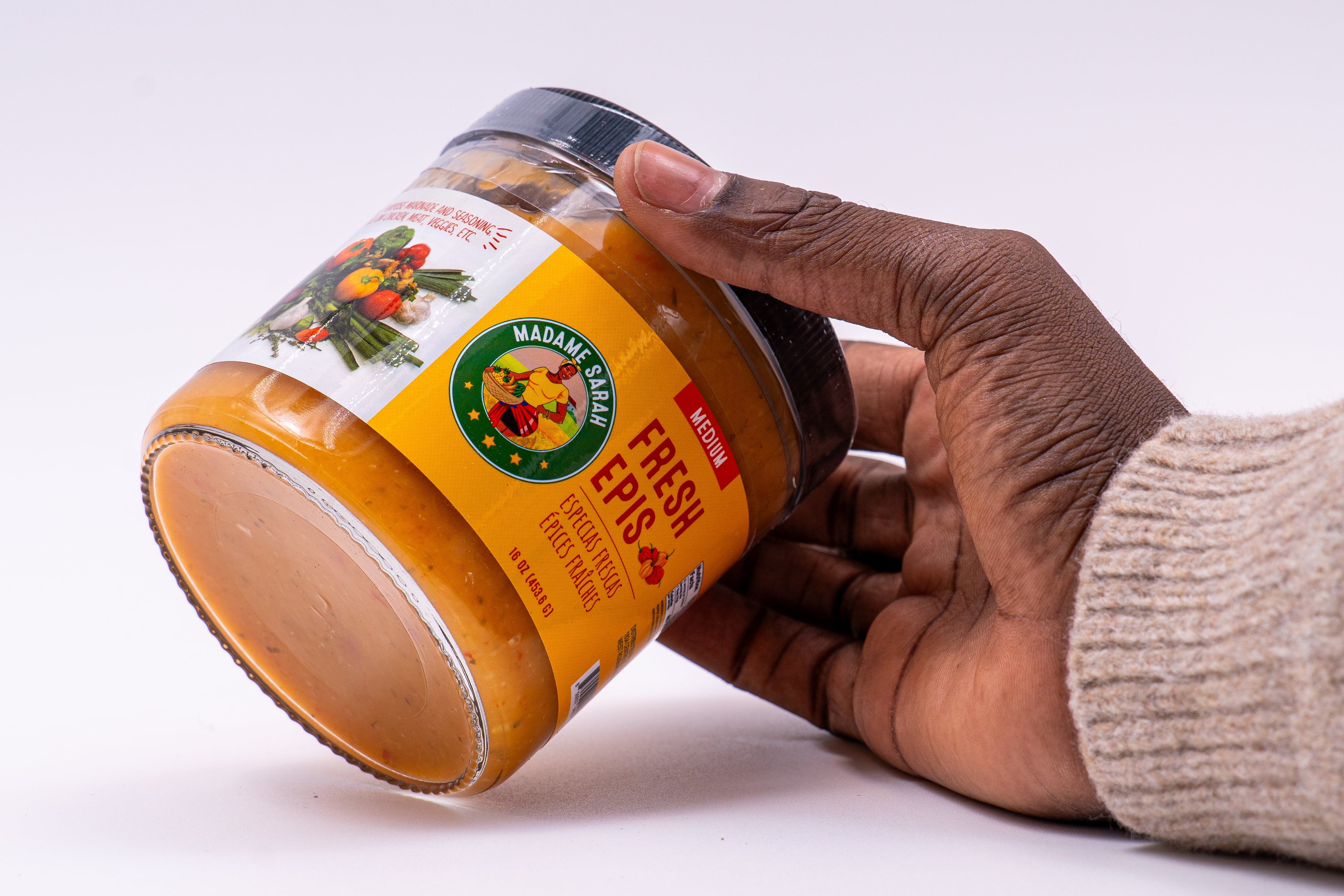 Hand holding a jar of Madame Sarah Fresh Haitian Epis Seasoning, medium spicy