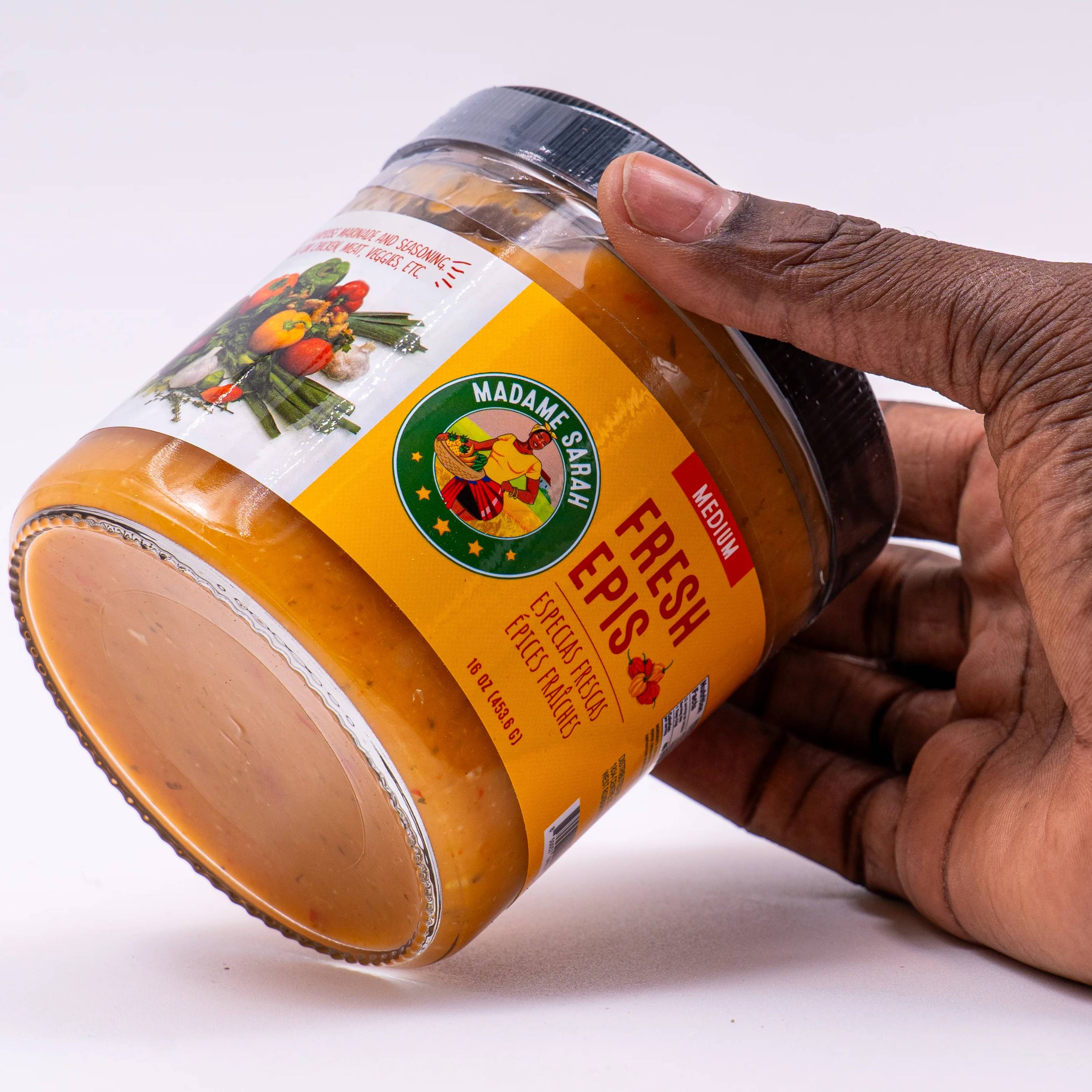 Hand holding a jar of Madame Sarah Fresh Epis Seasoning, medium spicy