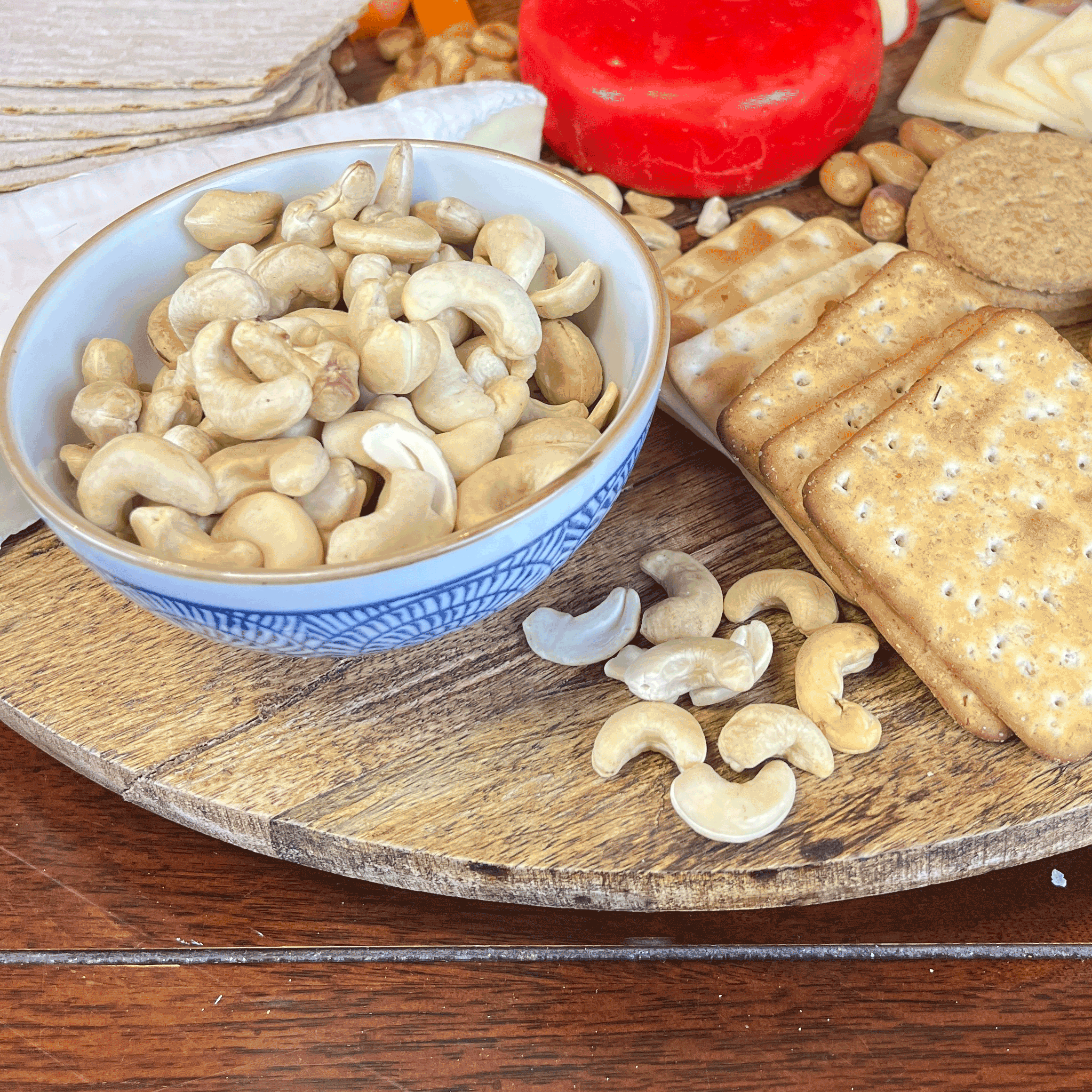 Madame Sarah raw cashews in a bowl on a platter with cheese and crackers